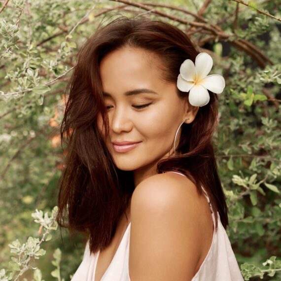 Radiating elegance, this Asian woman enchants with her graceful presence amidst a blooming garden. The flowers adorning her hair add a colorful and feminine touch to the composition. #EleganceInBloom #AsianCharm #FlowerAdorned