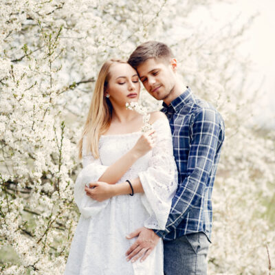 Cute couple in a park. Lady in a white dress. Guy in a blue shirt