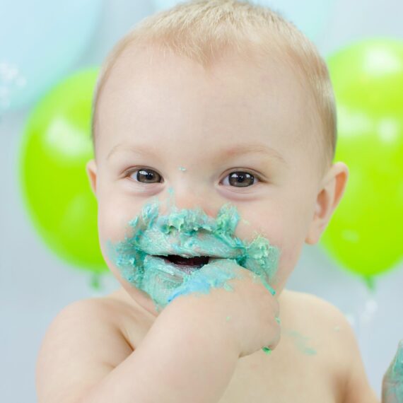 Joyful cake-covered toddler